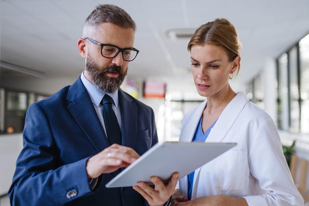 gestor e médica avaliando algo no tablet