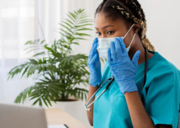 médica em consultório, observando prontuário e informações no notebook
