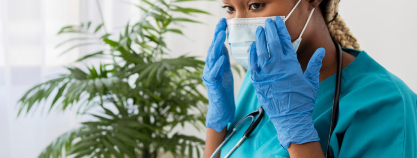 médica em consultório, observando prontuário e informações no notebook