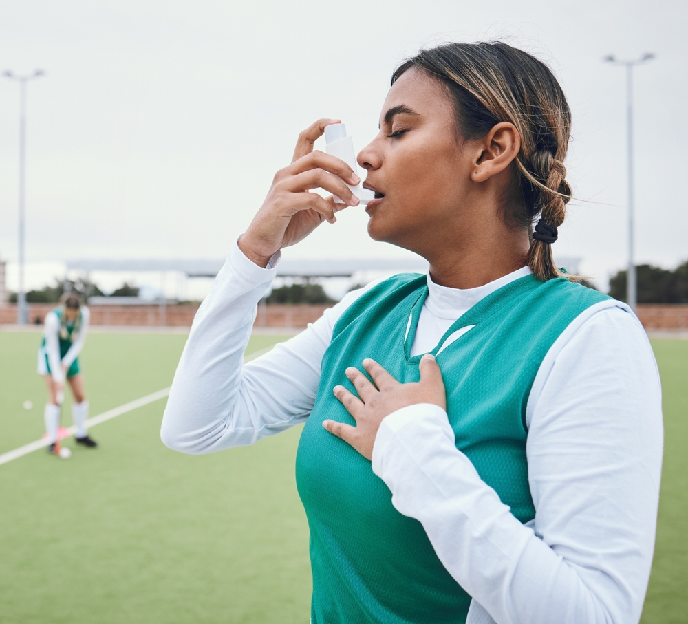 paciente utilizando bombinha de asma em espaço de esporte, durante a atividade