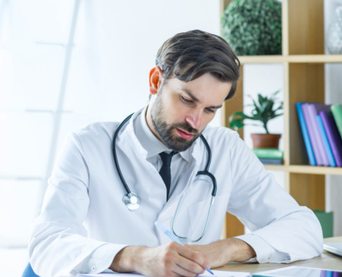 médico gestor em consultório preenchendo documento