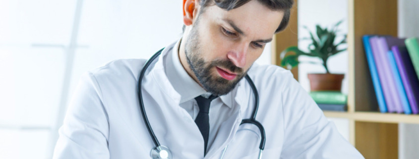 médico gestor em consultório preenchendo documento