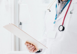 médico em consultório avaliando documento em mãos