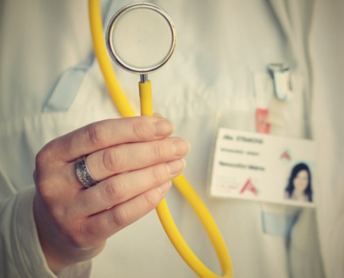 médico com jaleco branco segurando aparelho médico com cabo amarelo