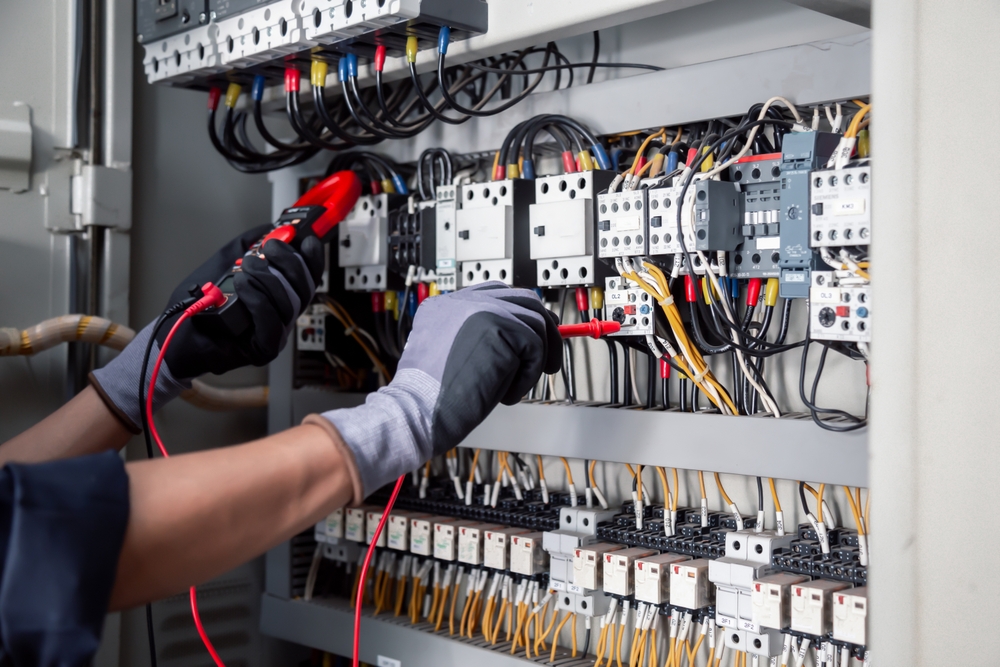 técnico manuseando equipamento elétrico de alta tensão utilizando luva específica