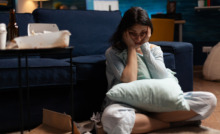 pessoa triste sentada no chão da sala com depressão