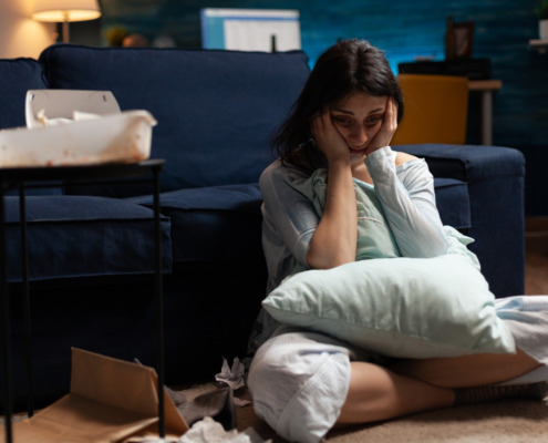 pessoa triste sentada no chão da sala com depressão