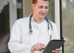 médico em área externa segurando tablet