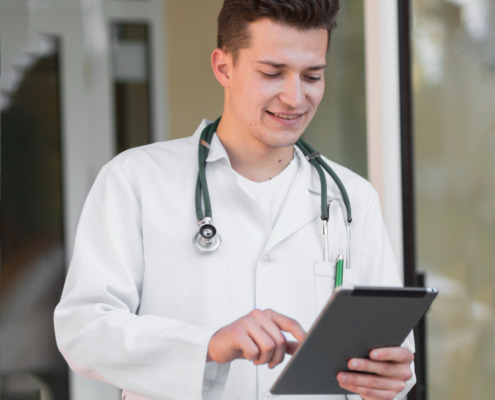 médico em área externa segurando tablet