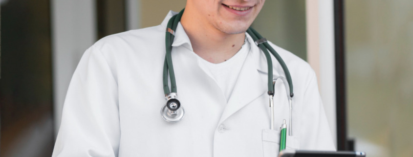 médico em área externa segurando tablet