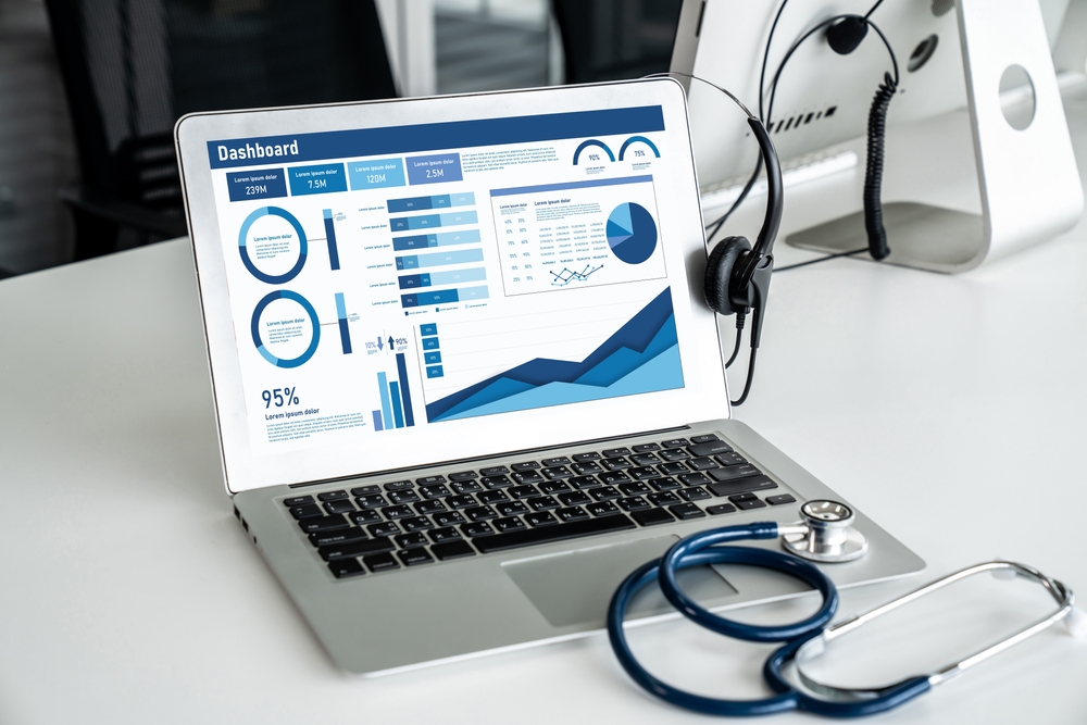 tela de notebook com dashboards e estetoscópio no teclado, indicando dados hospitalares