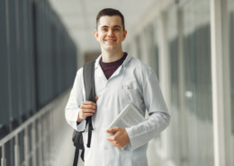estudante de medicina sorrindo em área externa de faculdade