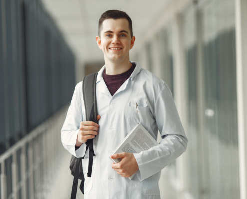 estudante de medicina sorrindo em área externa de faculdade