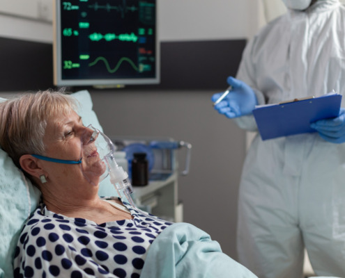 paciente em cama de hospital recebendo atendimento médico